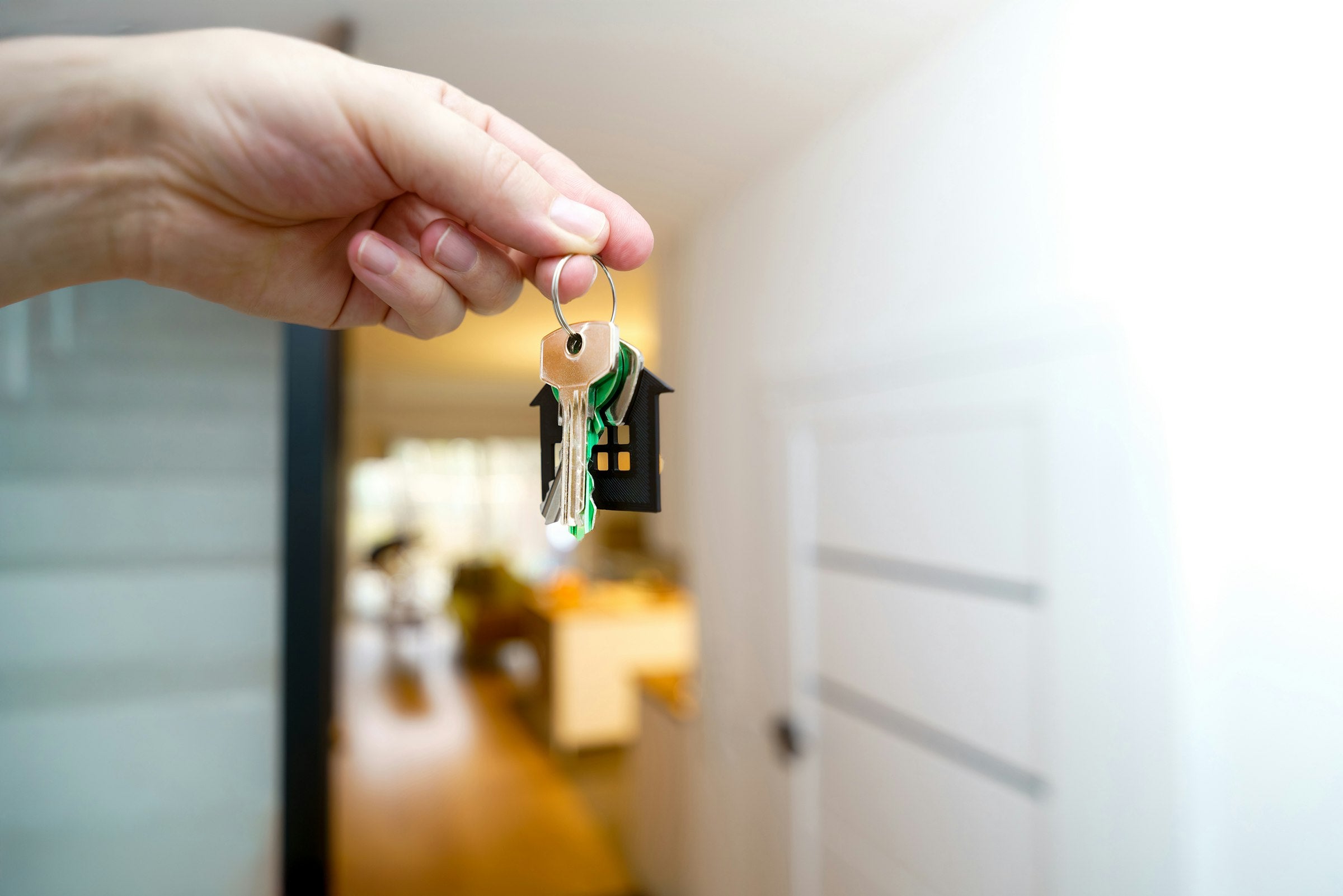 Personne tenant ses clés de maison devant l'entrée